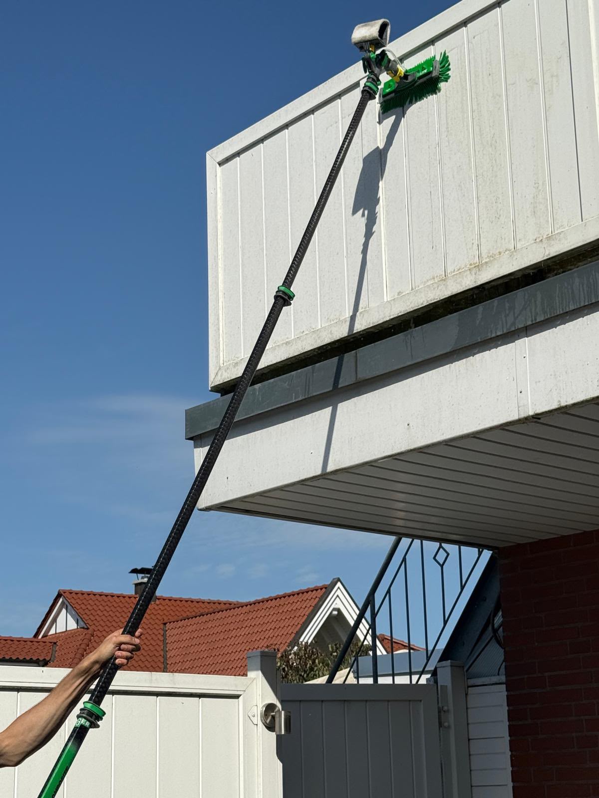 Fassadenreinigung mit Teleskopstange in Aktion